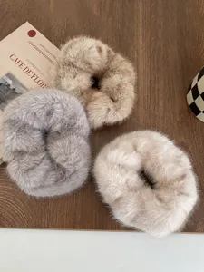 Gedetailleerd opname van pluizige nepbont haarelastiekjes met zachte winterse textuur.