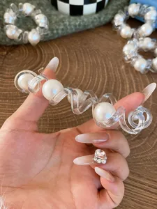 Primo piano dettagliato dell'elastico per capelli a spirale trasparente con perle.