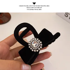 Black velvet hair claw clip featuring a sparkling rhinestone and pearl buckle for elegant styling.