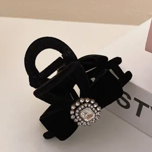 Black velvet hair claw clip with rhinestone bow, elegant vintage hairpin for women styling.