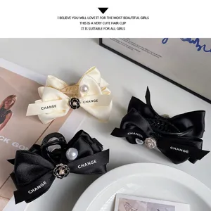 Elegant satin bow hair claw clip with pearl and camellia charm for women and girls daily wear.