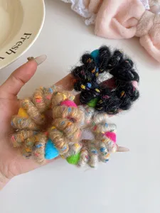 Detailed shot of fuzzy telephone wire hair ties with colorful pom poms, soft and elastic.