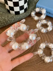 Dettaglio elastico per capelli a filo telefonico trasparente con perla, elastico e chic.