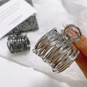 Pince à cheveux métallique argentée au design géométrique élégant pour coiffures chics.