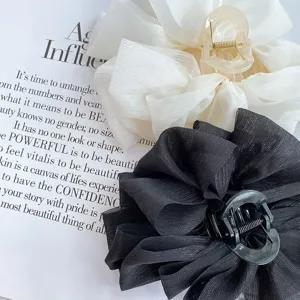 Detail shot of large organza bow hair claw clips in black and white, perfect styling close-up.