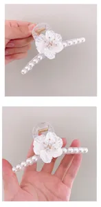 Vista detallada de la pinza de pelo flor de perla, diseño transparente con perlas blancas.