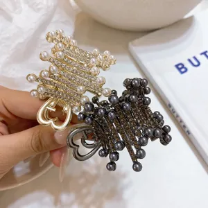Élégante pince à cheveux en métal perlé avec strass pour coiffure queue de cheval.