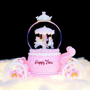 Pink carriage snow globe music box with rotating unicorns, glowing desktop decor.