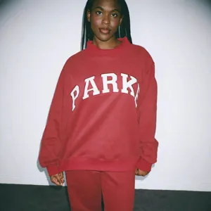 Women red crewneck sweatshirt with stylish white letter print, casual loose streetwear top.