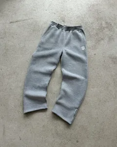 Grey casual sweatpants detail with wide leg design, bottom hem slit and embroidered logo.