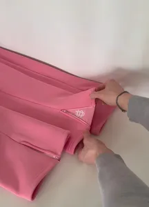 Detail shot of pink sweatpants showcasing the stylish zipper hem and embroidery craftsmanship.