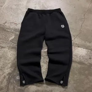 Black streetwear sweatpants with ankle zippers and embroidery details, stylish hip-hop pants.