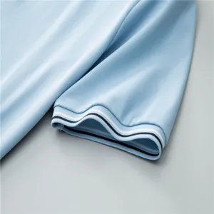 Close-up detail of light blue men's short sleeve polo shirt cuff with striped trim.