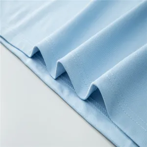 Close-up detail of light blue polo shirt fabric, showing breathable mesh texture and fine stitching.