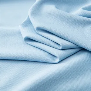 Light blue mesh fabric texture detail, breathable polo shirt material close up.