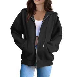 Close-up detail of women's black zip-up hoodie with hood, front pockets and relaxed fit.