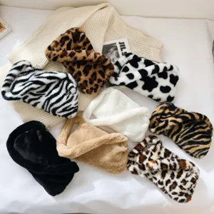 Close-up of various faux fur underarm bags in leopard and zebra patterns for winter