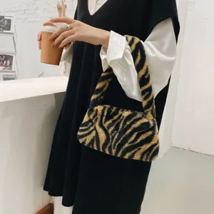 Detail view of a stylish tiger-print faux fur underarm shoulder bag for women