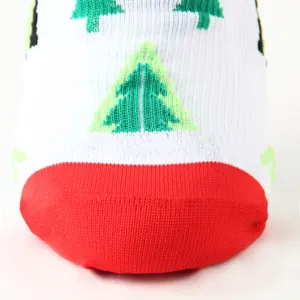 Detailansicht des gestrickten Weihnachtsbaummusters auf rot-weißen Kompressionsstrümpfen.