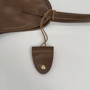 Detail view of a vintage brown leather tote bag showing the hanging key fob and strap