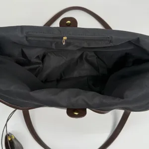 Detail view of tote bag interior featuring large capacity and black zipper pocket.