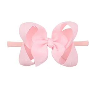 Detail of pink grosgrain ribbon bow on soft nylon headband for babies