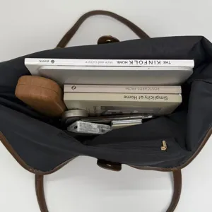 Detailed view showing the large capacity interior of a minimalist black tote bag.