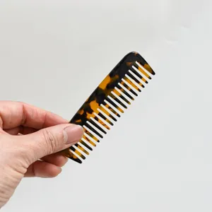 Dettaglio di un pettine a denti larghi in acetato tartarugato portatile per capelli