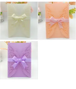 Three elegant colors of laser-cut hollow wedding invitation cards with matching satin ribbons