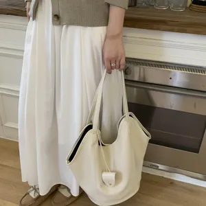 Close-up of minimalist off-white large capacity tote bag in commuter style