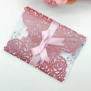Elegant pink glitter laser-cut wedding invitation card with ribbon bow and floral design