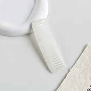 Primo piano di pettine in acetato bianco con elegante trama marmorea