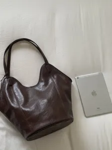 Minimalist large vintage brown tote bag for women shown next to a tablet for size scale