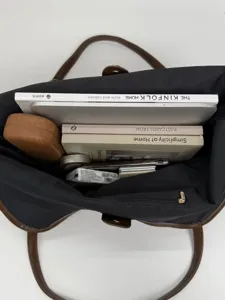 Large capacity minimalist black tote bag holding a laptop and books for commuting