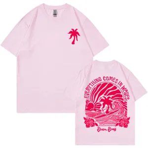 Camiseta rosa de algodón de manga corta con gráfico de surf de olas y estampado de palmas.