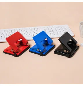 Detail shot of colorful double-hole paper punchers arranged on a clean desktop surface.