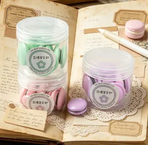 Macaron magnetic pins detail shot, strong magnets in jars on vintage book background.