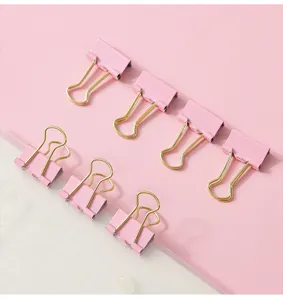 Clips metalliche rosa con impugnatura dorata per cancelleria e gestione documenti.