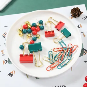 Weihnachts Schreibwaren Set mit roten, grünen und goldenen Büroklammern und bunten Heftzwecken.