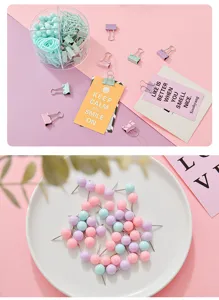 Set de papelería color macaron con recipiente transparente, sujetapapeles, pinzas y chinchetas.