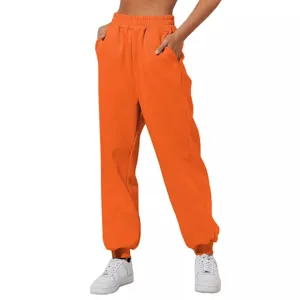 Primo piano di pantaloni da jogging arancioni a vita alta con comode tasche ed elastico in vita.