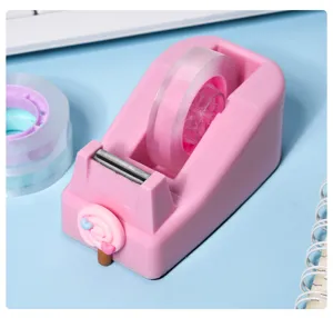 Macaron pink tape dispenser detail showing cute lollipop design and clear tape on desk.