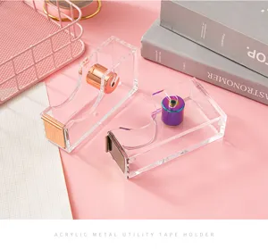 Clear acrylic tape dispenser with rose gold and rainbow metal core for desktop use, detail view.