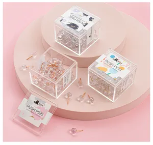 Close-up detail of clear round push pins in transparent plastic storage boxes, elegant.