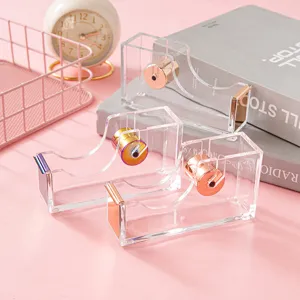 Clear acrylic tape dispenser with rose gold and colorful metal cutter for desktop office use.