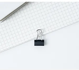 Détail de pince à relier en métal noir, clip de papeterie durable pour organiser les papiers.