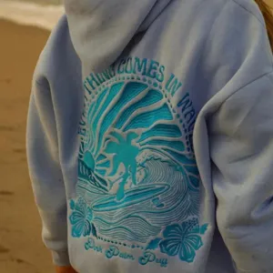 Dettaglio felpa con cappuccio da donna con grafica ricamata di onda da surf sul retro.