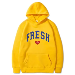 Nahaufnahme des gelben Hoodies mit blauem FRESH-Schriftzug und rotem Herzprint vorne.