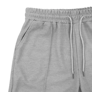 Grey waffle knit shorts detail featuring elastic drawstring waistband and side pockets.