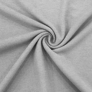 Grey waffle knit fabric detail closeup, soft breathable textile texture for apparel design.